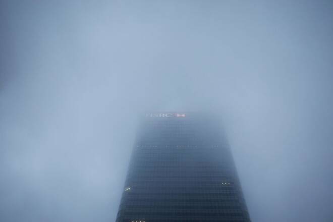 The logo on the building of HSBC's London headquarters appears through the early morning mist in London's Canary Wharf financial district