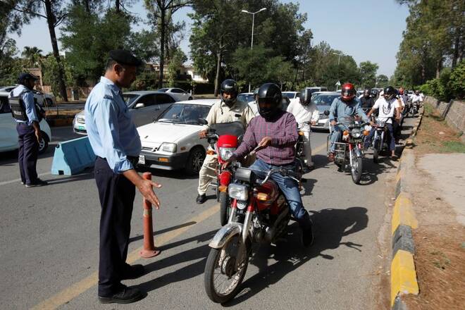 Police officers check identity passes of the commuters entering Red Zone for their offices, ahead of the planned protest march towards Islamabad led by ousted Prime Minister Imran Khan, in Islamabad