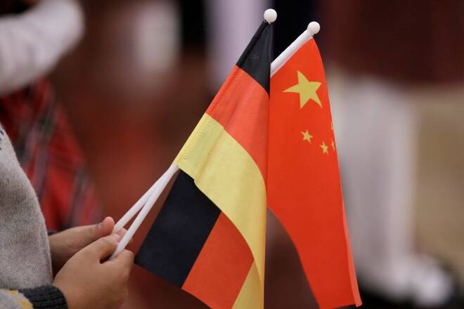 A student holds flags of China and Germany before a welcome ceremony in Beijing