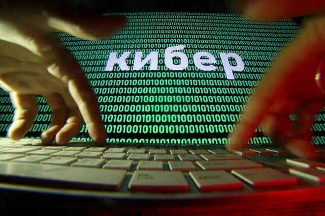 Hands are seen on a keyboard in front of a displayed cyber code in this picture illustration