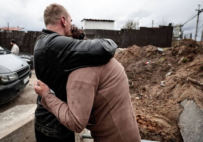 A mother reacts as she waits for police members to exhume the body of her dead son from a well at a fuel station in Buzova