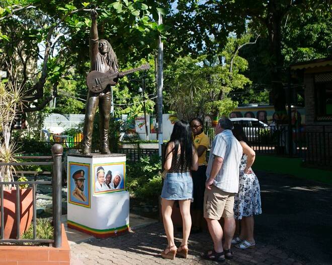 Tourists view a statue of Bob Marley outside the Bob Marley Museum in Kingston