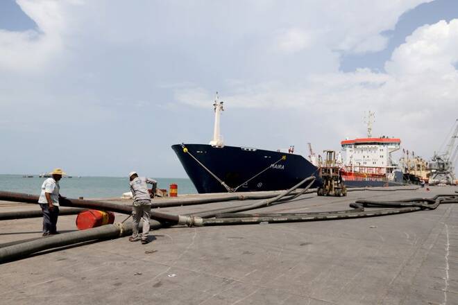 Workers prepare to unload a fuel shipment from an oil tanker at the port of Hodeidah, Yemen