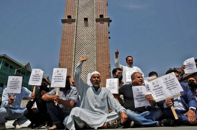 Demonstrators hold placards as they shout slogans during a protest against minorities killings in Kashmir, in Srinagar