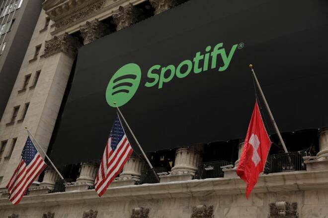 The Spotify logo hangs on the facade of the New York Stock Exchange with U.S. and a Swiss flag as the company lists its stock with a direct listing in New York