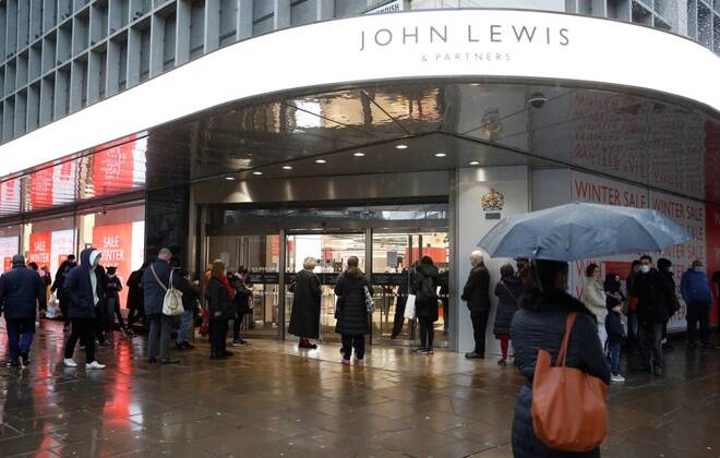 People queue outside a John Lewis a store announcing a seasonal sale, in London
