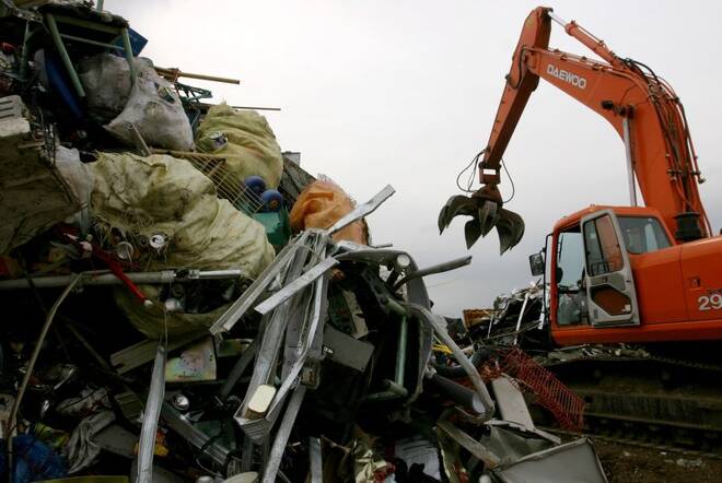 A South Korean worker operates a crane beside of a heap of iron scrap