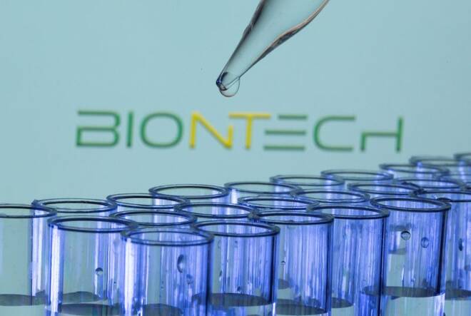 Test tubes are seen in front of a displayed Biontech logo in this illustration