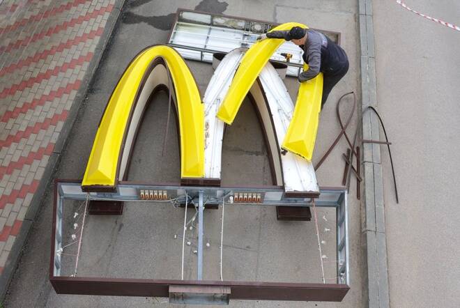 Workers remove the logo of McDonald's in Kingisepp