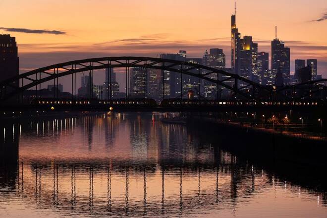 A commuter train passes by the skyline with its financial district in Frankfurt