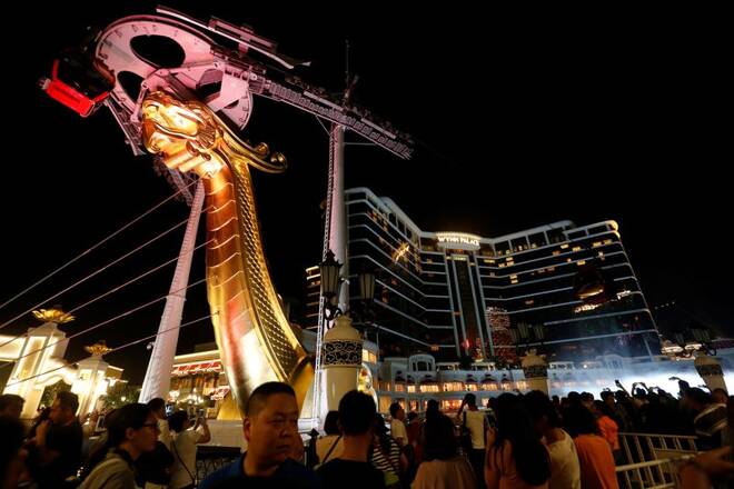 People wait to get in outside Wynn Palace during its opening in Macau