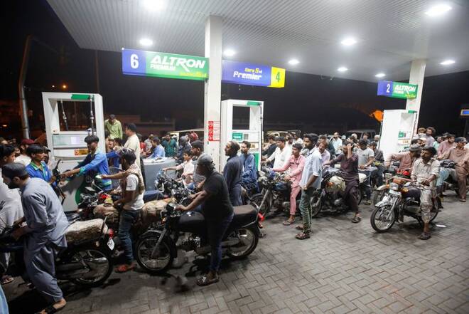 People wait to get fuel at a petrol station, in Karachi