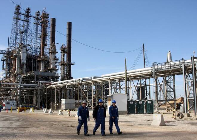 Refinery workers walk inside the LyondellBasell oil refinery in Houston