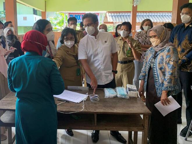 Indonesia's Health Minister Budi Gunadi Sadikin talks to a health official during a tuberculosis screening in Yogyakarta