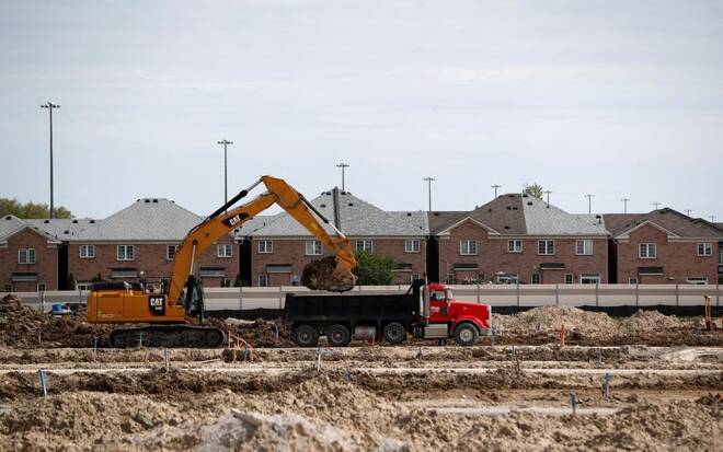 Construction workers build homes on a lot in Vaughan, Ontario