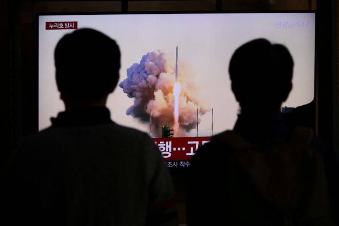 People watch a TV broadcasting a news report on the KSLV-II NURI rocket launching from its launch pad of the Naro Space Center, at a railway station in Seoul