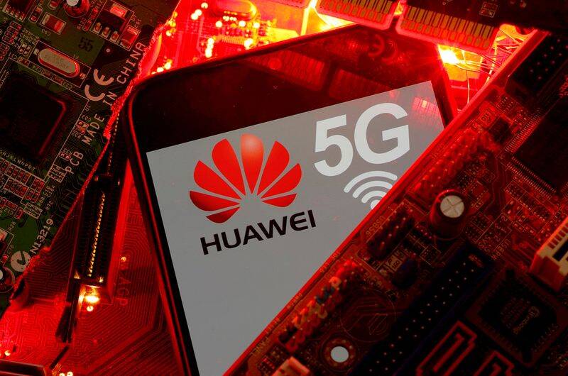 A smartphone with the Huawei and 5G network logo is seen on a PC motherboard in this illustration