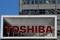 Logo of Toshiba Corp is seen as window cleaners work on the company's headquarters in Tokyo