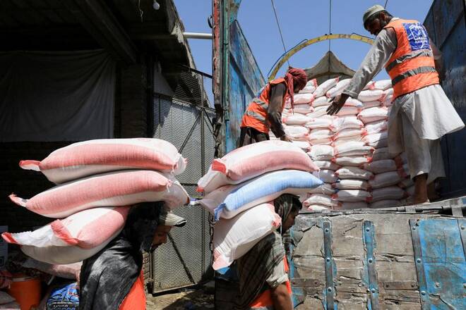 Volunteers from the Al-Khidmat Foundation load sacks of flour on a truck for the people affected by the earthquake in Afghanistan, in Peshawar