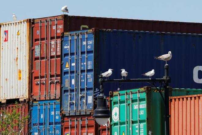 Sea gulls sit on a lamppost beside shipping containers stacked at the Paul W. Conley Container Terminal in Boston