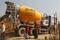 Workers walk in front of an UltraTech concrete mixture truck at the construction site of a commercial complex on the outskirts of Ahmedabad