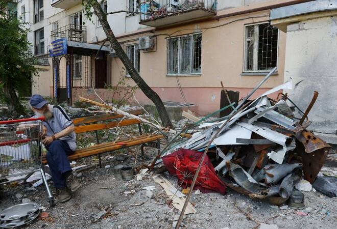 A local resident sits on a bench near a damaged apartment building in Sievierodonetsk
