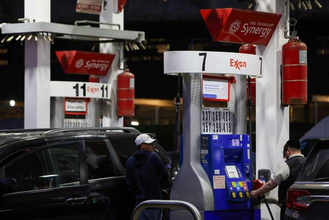 People pump gas at an Exxon gas station in Brooklyn, New York City