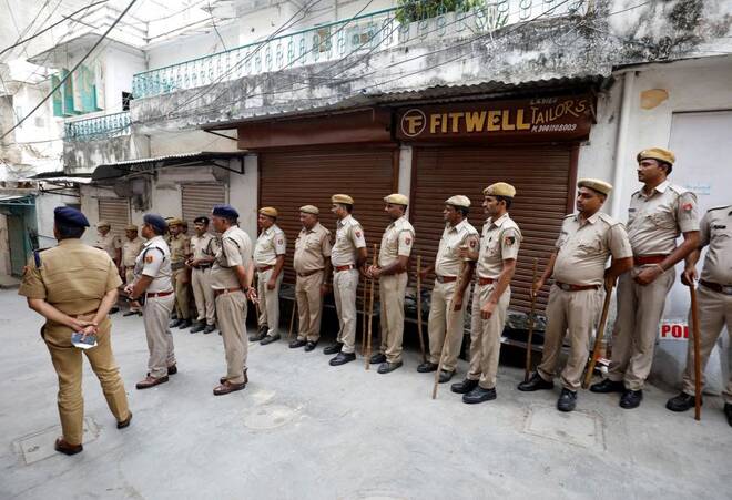 Police stand next to the shop of Kanhaiyalal Teli, a Hindu tailor, in Udaipur
