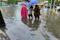 Pedestrians wade through floodwaters on a street as Typhoon Chaba hits Sanya