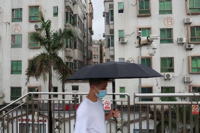 Man walks past surveillance cameras near Caopu in Shenzhen