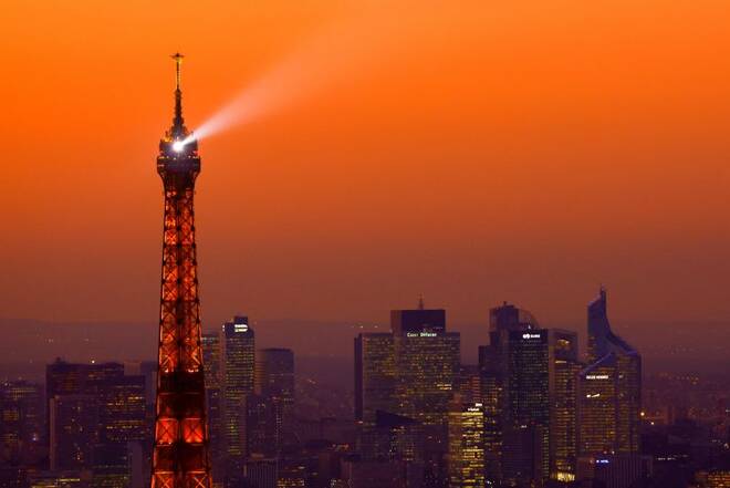 A view at sunset shows the Eiffel Tower and the financial and business district of La Defense in Puteaux near Paris