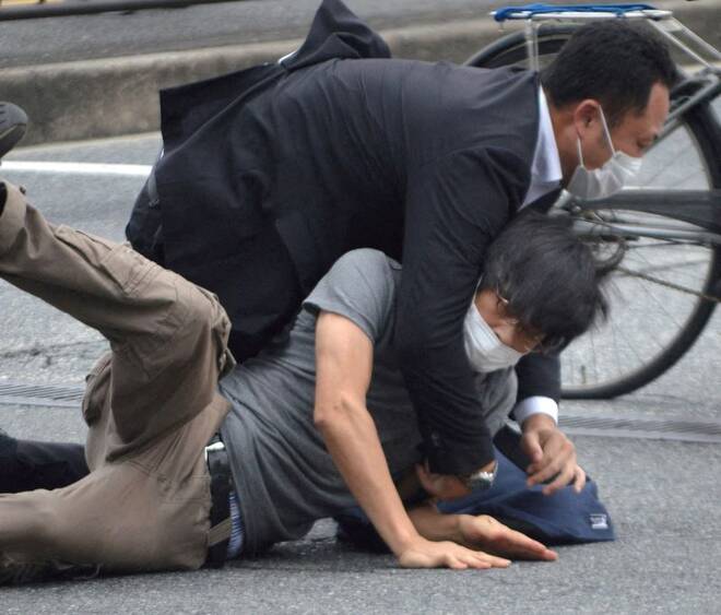 A man, believed to be a suspect shooting former Japanese Prime Minister Shinzo Abe is held by police officers at Yamato Saidaiji Station in Nara