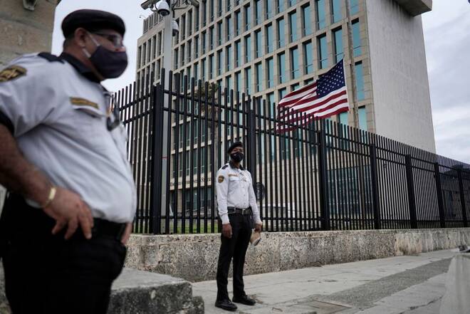 The U.S. flag flies next to security guarding the U.S. embassy in Havana