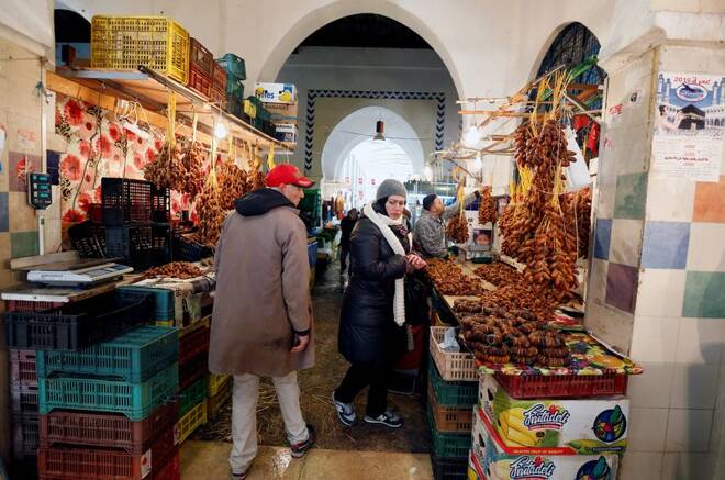 A women looks at dates at a market in Tunis