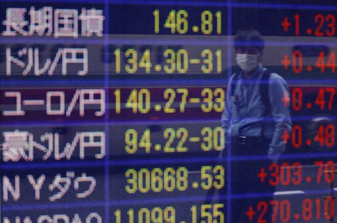 A man looks at a board displaying the Japanese yen exchange rate against the U.S. dollar outside a brokerage in Tokyo