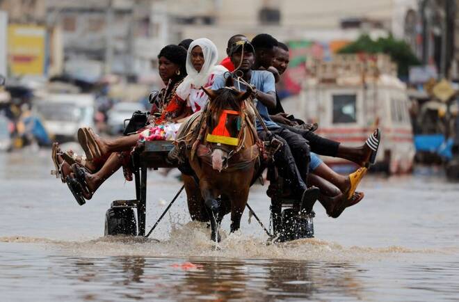 Residents make their way through a flooded street after heavy rains in Yoff, district of Dakar