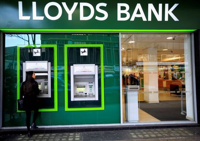 A woman uses a cash machine at a Lloyds Bank branch in central London