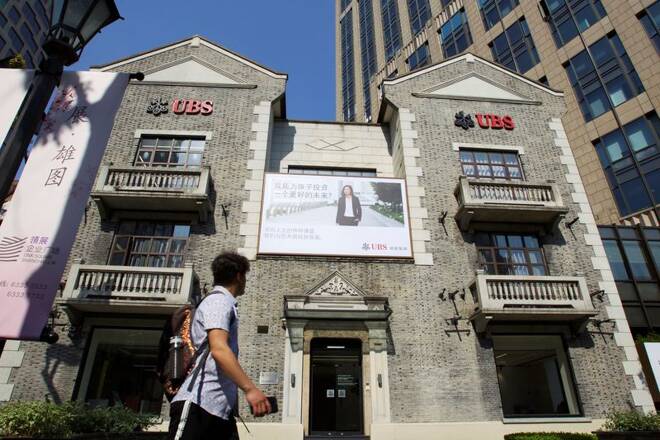 Man walks past a building of Swiss bank UBS in Shanghai