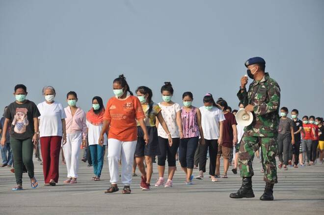 Indonesian migrant workers who arrived from Malaysia exercise during quarantine to prevent the spread of coronavirus disease (COVID-19) at Soewondo air base in Medan