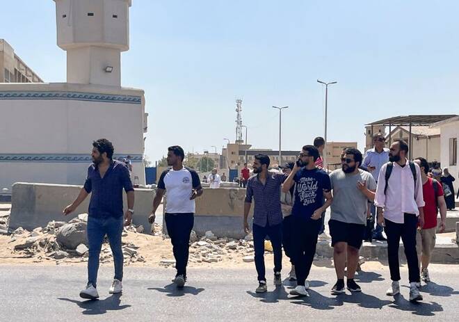 Alaa Essam, one of a group of newly released detainees walks across the road with his family and friends after leaving Tora prison in a suburb of Cairo
