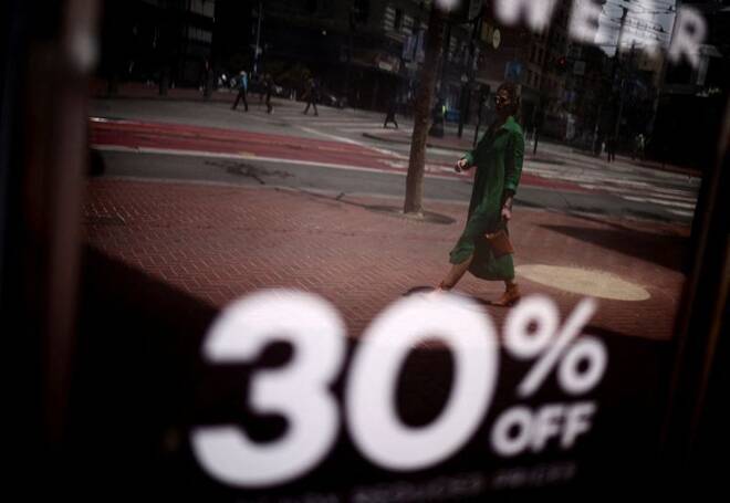 A woman walks by a local shop as discounts are displayed, in downtown San Francisco, California