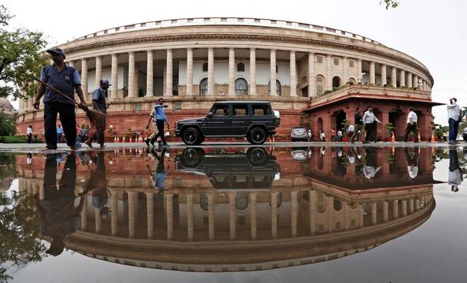 Indian parliament building is reflected in a puddle after the rain in New Delhi
