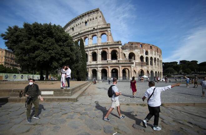 People walk outside the Colosseum, in Rome