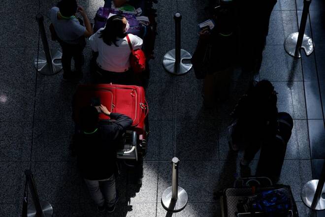Travellers queue up for shuttle bus to quarantine hotels at the Hong Kong International Airport, amid the coronavirus disease (COVID-19) pandemic, in Hong Kong