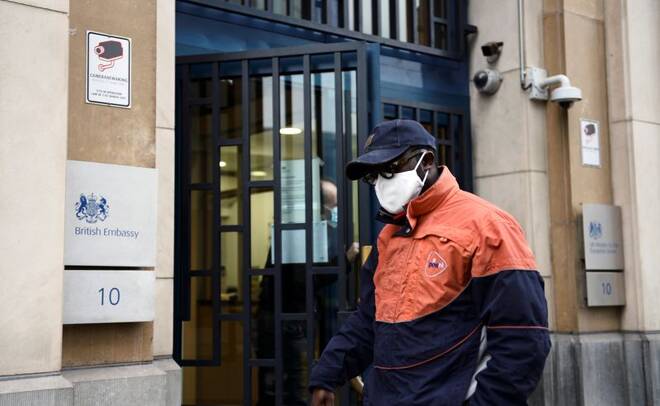 A PostNL employee is seen at the entrance of the UK Mission to the EU