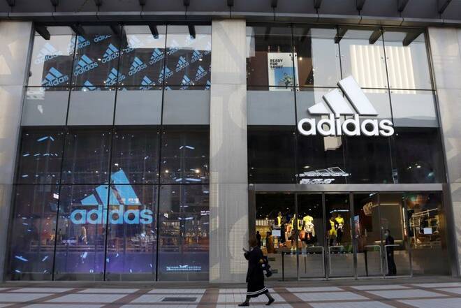 Woman walks past an Adidas store at a shopping mall in Beijing