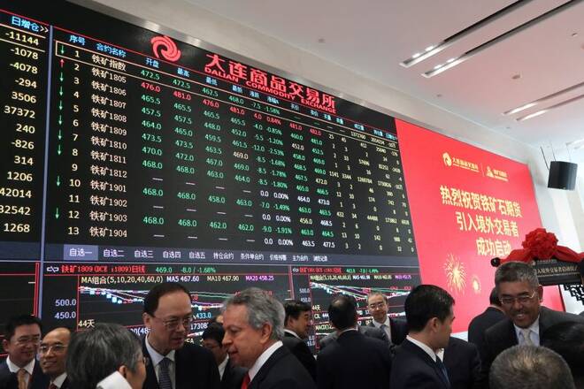 People attend a ceremony marking the opening of iron ore futures to foreign investors, at Dalian Commodity Exchange in Dalian