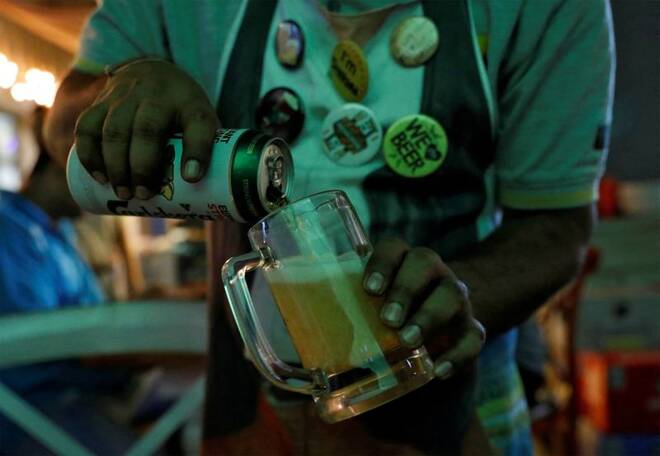 A waiter pours Carlsberg beer at a pub in Mumbai
