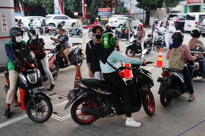 Motorcycle drivers wait in line to buy subsidised fuel at a petrol station of the state-owned company Pertamina, in Jakarta,