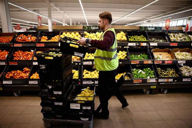 A employee arranges produce inside a Sainsbury’s supermarket